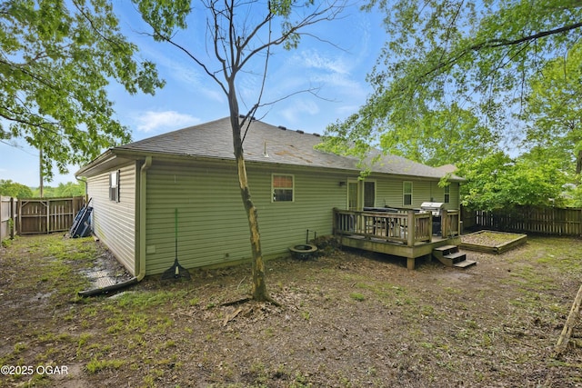 rear view of property with a fenced backyard and a deck
