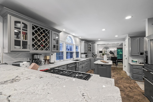 kitchen with gray cabinets, stainless steel appliances, backsplash, glass insert cabinets, and recessed lighting