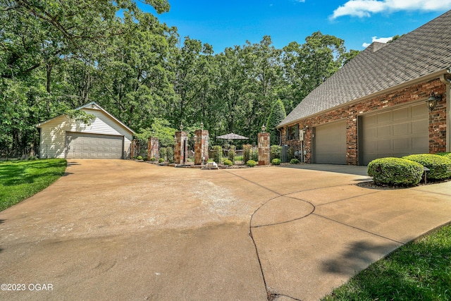 view of front of home with an outdoor structure, a garage, brick siding, roof with shingles, and fence