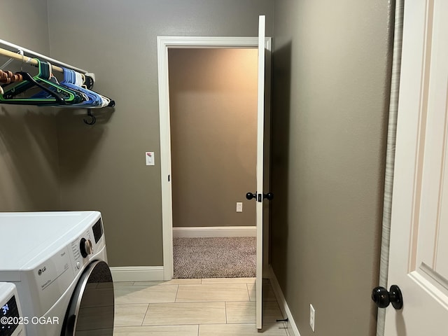 clothes washing area with washing machine and dryer and baseboards