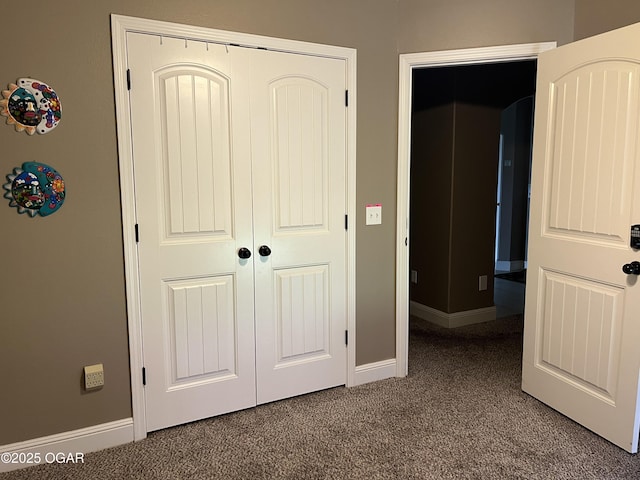 unfurnished bedroom with baseboards, carpet, and a closet