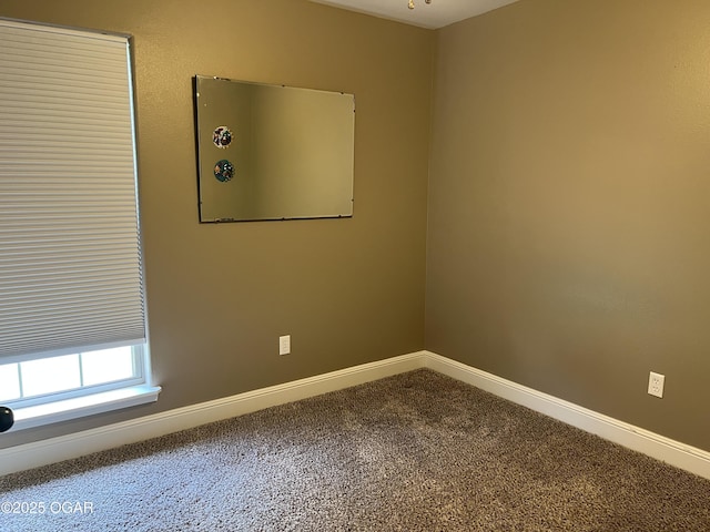 carpeted empty room featuring baseboards