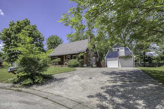 view of front facade with concrete driveway, a garage, an outbuilding, and a chimney