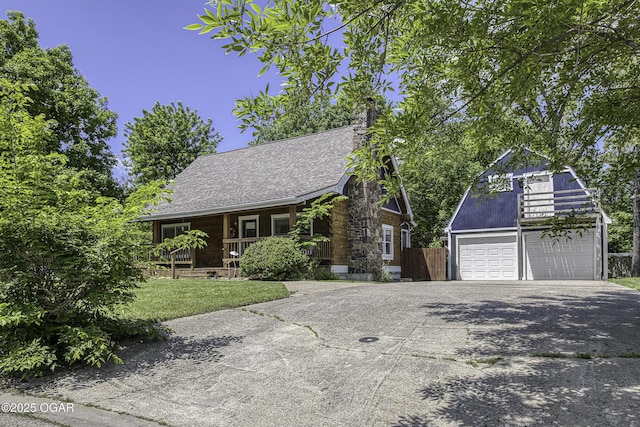 view of front of house featuring a garage, a porch, concrete driveway, and fence
