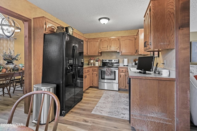 1617 Alexandra Dr, Carthage, MO 64836 - kitchen with stainless steel electric range oven, black fridge with ice dispenser, light wood finished floors, light countertops, and a chandelier