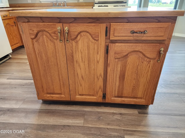 208 NW 10th Rd, Lamar, MO 64759 - detailed view of wood finished floors, stove, a sink, and white microwave