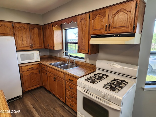 208 NW 10th Rd, Lamar, MO 64759 - kitchen featuring white appliances, a sink, under cabinet range hood, dark wood-style floors, and brown cabinetry
