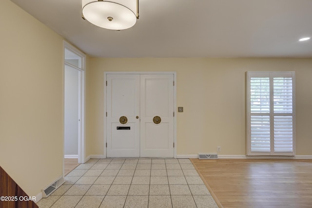 foyer with baseboards and light tile patterned floors