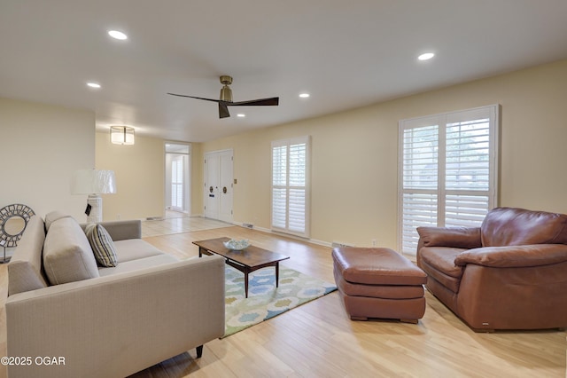 living room with a ceiling fan, light wood-style floors, recessed lighting, and baseboards