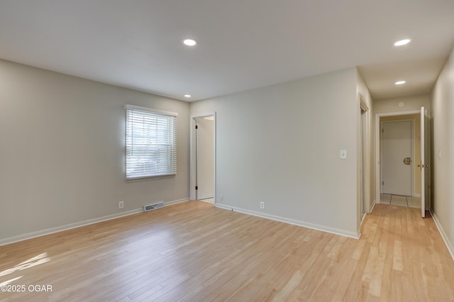 spare room with light wood-style flooring, baseboards, and recessed lighting