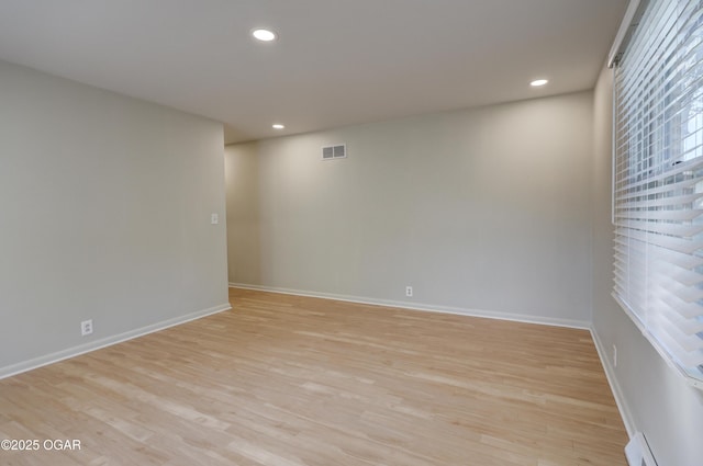 unfurnished room with a baseboard radiator, light wood finished floors, baseboards, and recessed lighting