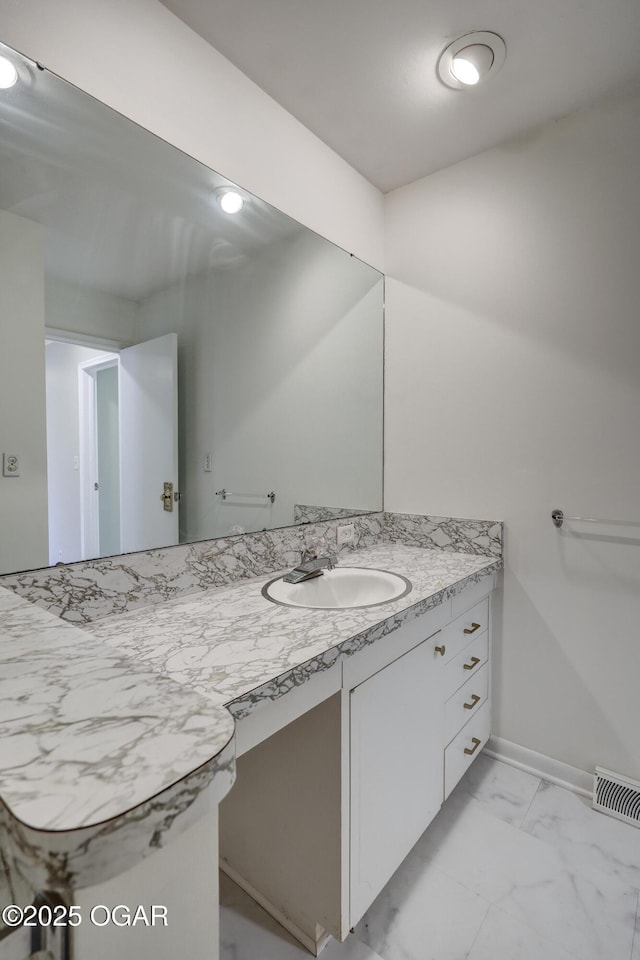 bathroom with marble look tile flooring, vanity, and baseboards