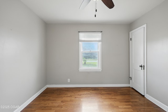 unfurnished room featuring wood finished floors, ceiling fan, and baseboards