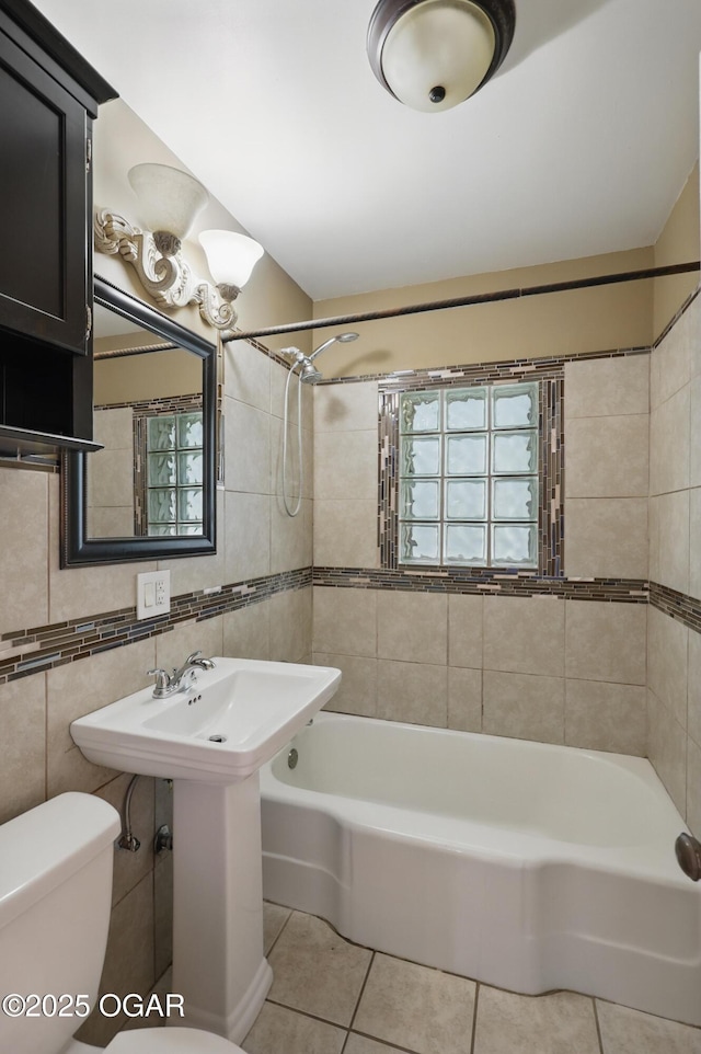 full bathroom with tile patterned floors, toilet, bathtub / shower combination, and tile walls