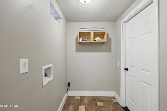 washroom featuring baseboards, washer hookup, and dark stone finish floors
