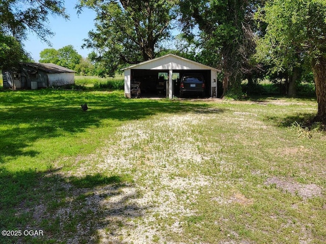 6468 Dogwood Rd, Reeds, MO 64859 - view of green lawn featuring a garage and a carport