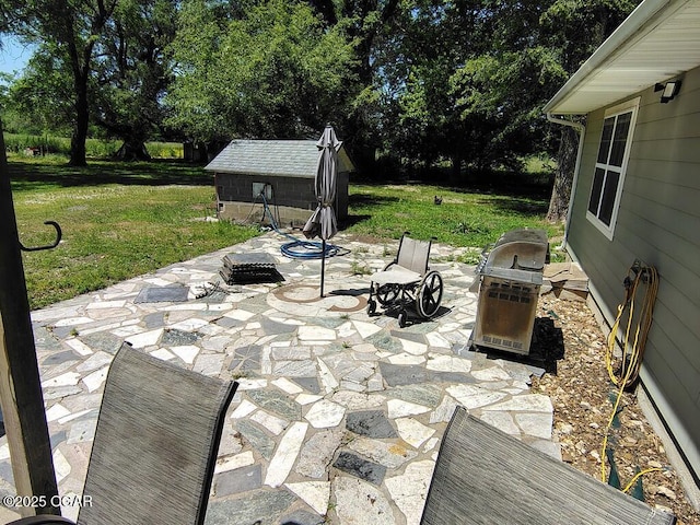 6468 Dogwood Rd, Reeds, MO 64859 - view of patio / terrace with an outdoor structure, view of wooded area, and a storage unit
