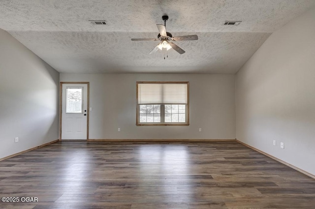 empty room featuring a textured ceiling, a ceiling fan, wood finished floors, and baseboards