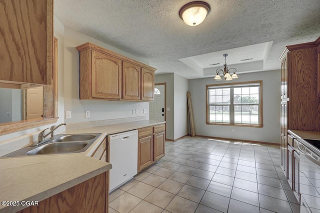 kitchen featuring white dishwasher, a sink, a raised ceiling, a textured ceiling, and a chandelier