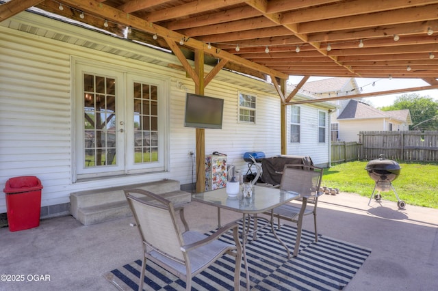 view of patio / terrace featuring fence, french doors, entry steps, and outdoor dining area