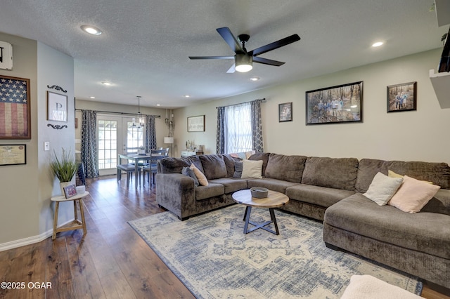 living area featuring healthy amount of natural light, dark wood-style flooring, a textured ceiling, ceiling fan, and recessed lighting