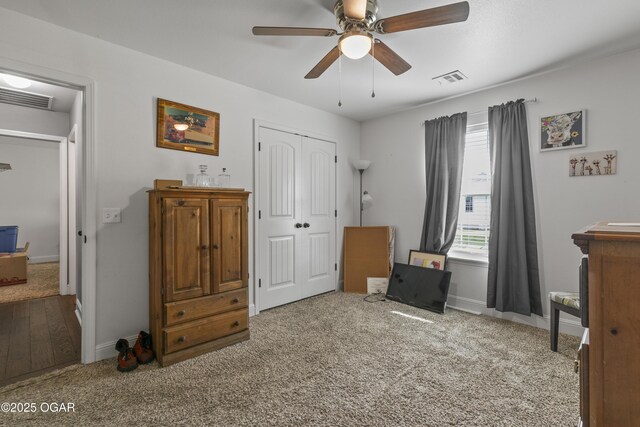 carpeted bedroom with a closet, baseboards, and a ceiling fan