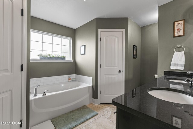 full bathroom with a garden tub, double vanity, and tile patterned floors