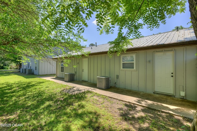 238 E 21st St, Baxter Springs, KS 66713 - rear view of property featuring board and batten siding, a yard, and central AC
