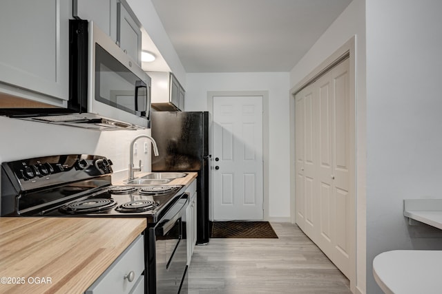 238 E 21st St, Baxter Springs, KS 66713 - kitchen featuring black appliances, a sink, and light wood-type flooring
