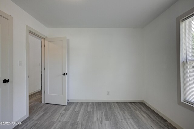 238 E 21st St, Baxter Springs, KS 66713 - unfurnished bedroom featuring light wood-style flooring and baseboards