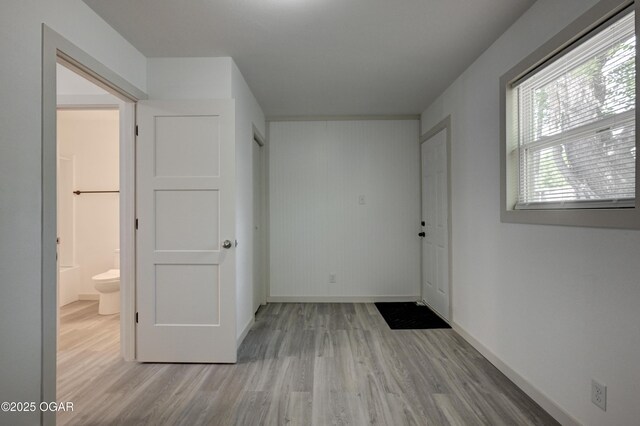 238 E 21st St, Baxter Springs, KS 66713 - unfurnished bedroom with wood finished floors, baseboards, and ensuite bathroom