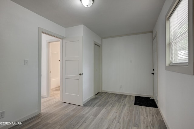 238 E 21st St, Baxter Springs, KS 66713 - unfurnished bedroom featuring baseboards, light wood-style floors, and a closet