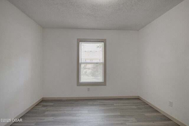 238 E 21st St, Baxter Springs, KS 66713 - spare room featuring wood finished floors, a textured ceiling, and baseboards