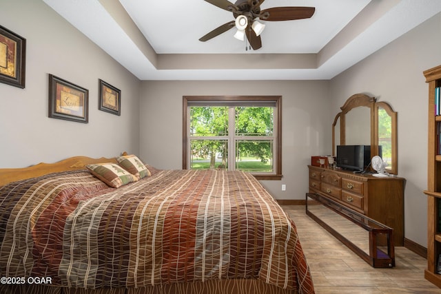 12244 County Rd 227, Oronogo, MO 64855 - bedroom with wood finished floors, a tray ceiling, a ceiling fan, and baseboards