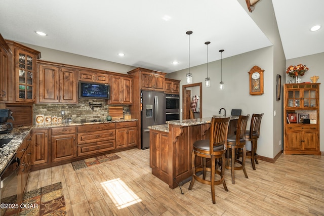12244 County Rd 227, Oronogo, MO 64855 - kitchen featuring appliances with stainless steel finishes, a kitchen breakfast bar, light wood-type flooring, decorative backsplash, and recessed lighting