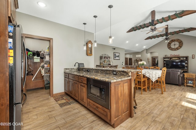 12244 County Rd 227, Oronogo, MO 64855 - kitchen with built in microwave, freestanding refrigerator, a breakfast bar area, lofted ceiling, and light wood-type flooring