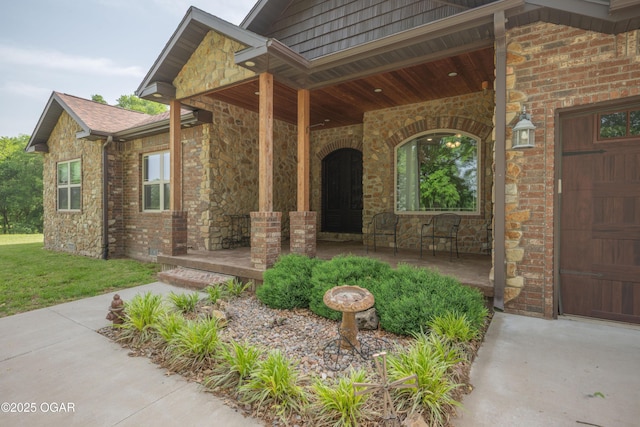 12244 County Rd 227, Oronogo, MO 64855 - view of exterior entry featuring covered porch, stone siding, a garage, and a yard