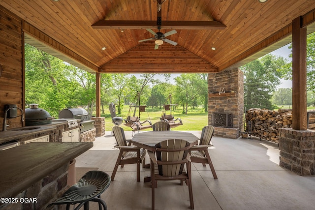 12244 County Rd 227, Oronogo, MO 64855 - view of patio featuring an outdoor stone fireplace, outdoor dining space, area for grilling, an outdoor kitchen, and ceiling fan