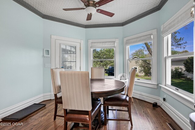 dining space with a ceiling fan, dark wood-style flooring, ornamental molding, and baseboards