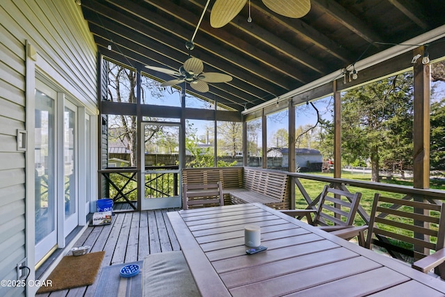 unfurnished sunroom with ceiling fan and vaulted ceiling