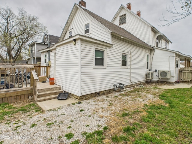 720 Chestnut Ave, Joplin, MO 64801 - back of property featuring a chimney, a cooling unit, a wooden deck, and roof with shingles
