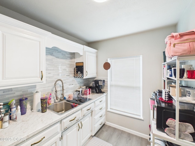 720 Chestnut Ave, Joplin, MO 64801 - kitchen with a sink, tasteful backsplash, light countertops, and white cabinets