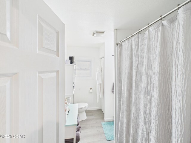 720 Chestnut Ave, Joplin, MO 64801 - full bath with wood finished floors, toilet, a shower with curtain, and baseboards