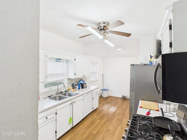720 Chestnut Ave, Joplin, MO 64801 - kitchen with a sink, a ceiling fan, gas stove, light countertops, and white cabinetry