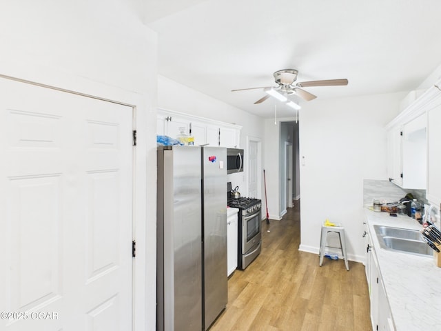 720 Chestnut Ave, Joplin, MO 64801 - kitchen with appliances with stainless steel finishes, a sink, a ceiling fan, white cabinetry, and light countertops