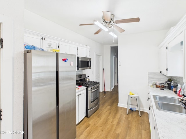 720 Chestnut Ave, Joplin, MO 64801 - kitchen featuring stainless steel appliances, white cabinets, a ceiling fan, and a sink