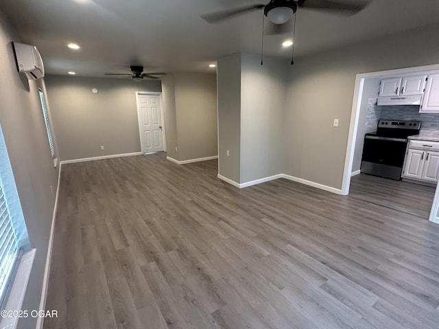 720 Chestnut Ave, Joplin, MO 64801 - unfurnished living room with ceiling fan, a wall mounted AC, wood finished floors, baseboards, and recessed lighting