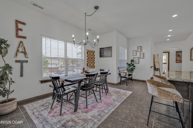 dining room with a chandelier, recessed lighting, arched walkways, baseboards, and dark tile patterned floors