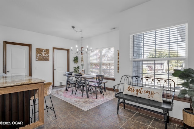 dining space featuring a chandelier, healthy amount of natural light, and baseboards