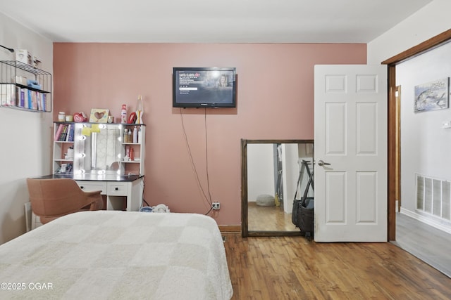 bedroom featuring wood finished floors and baseboards